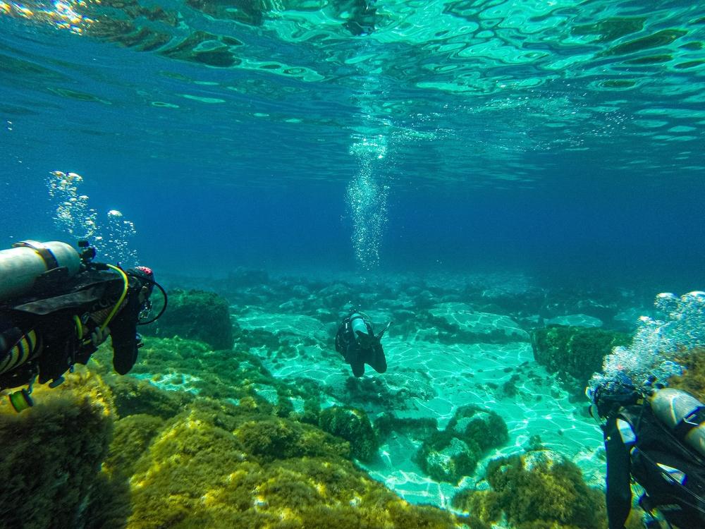 Divers exploring the bridge area of the Zenobia wreck with panoramic views