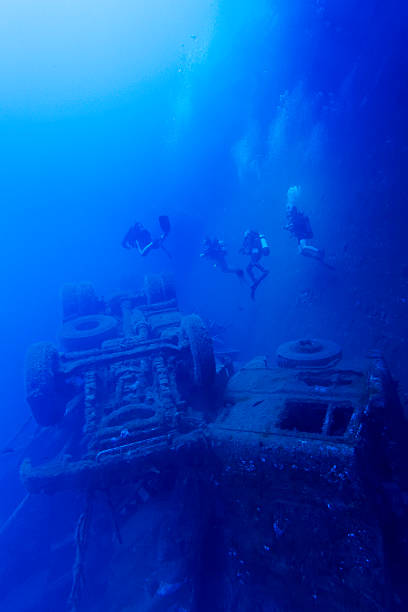 Divers exploring the Zenobia wreck dive in Larnaca, Cyprus at depth with truck cargo structures visible